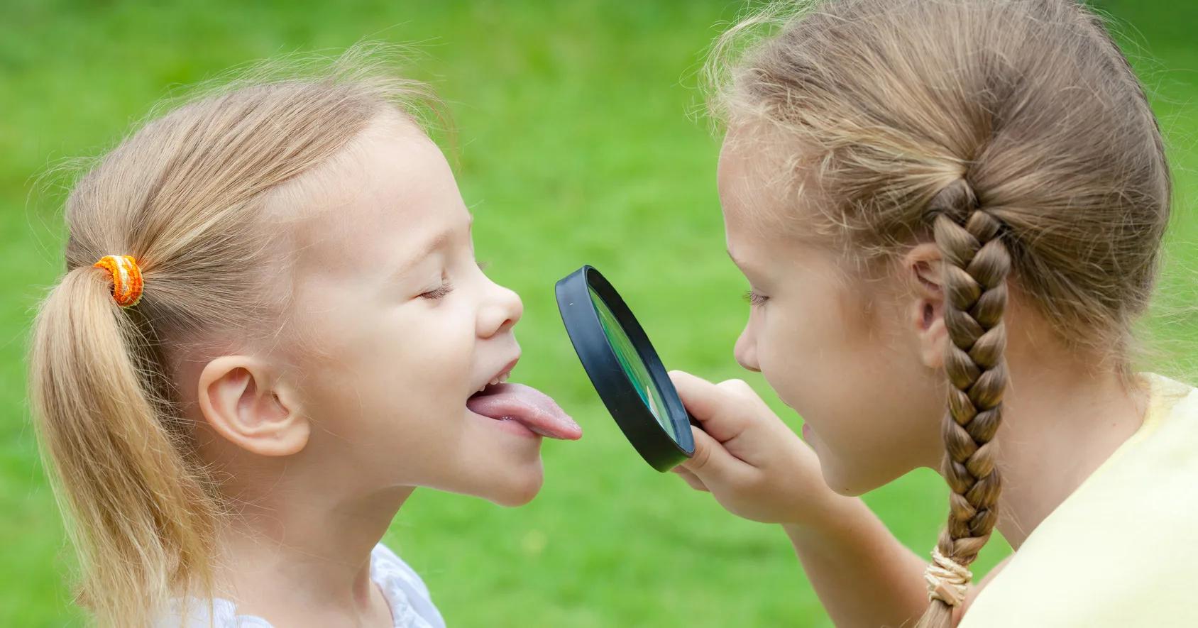 Zwei Kinder entdecken gemeinsam etwas mit einer Lupe